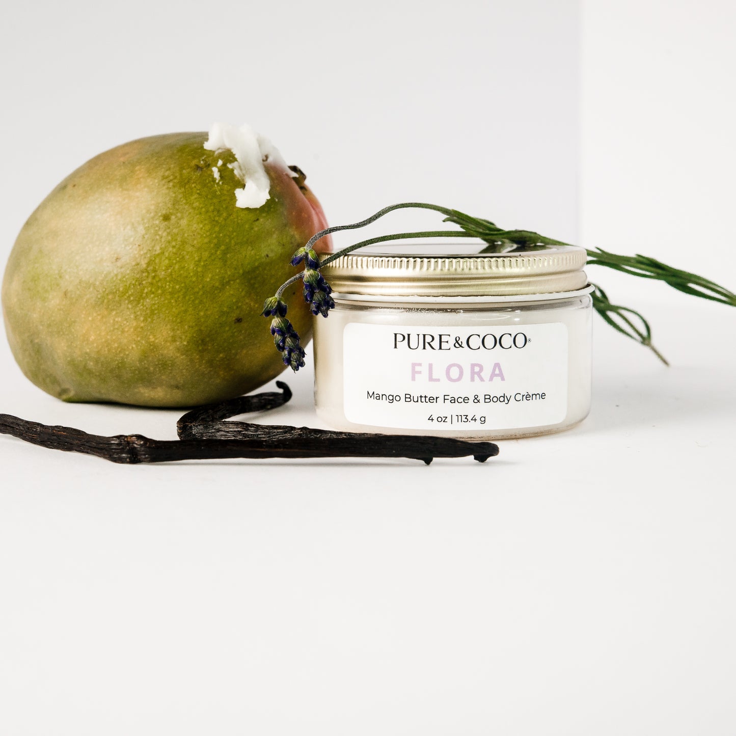 mango sitting next to the jar of Flora Mango Butter Face & Body Creme_4 oz_Pure and Coco with vanilla and lavender next to both iteams