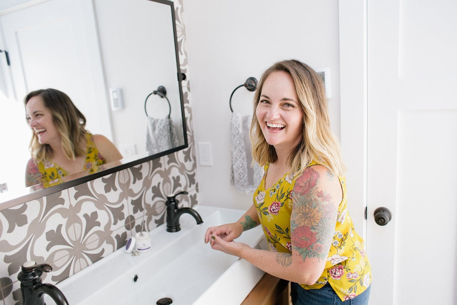 woman holding moisturizing sugar scrub in the master bathroom