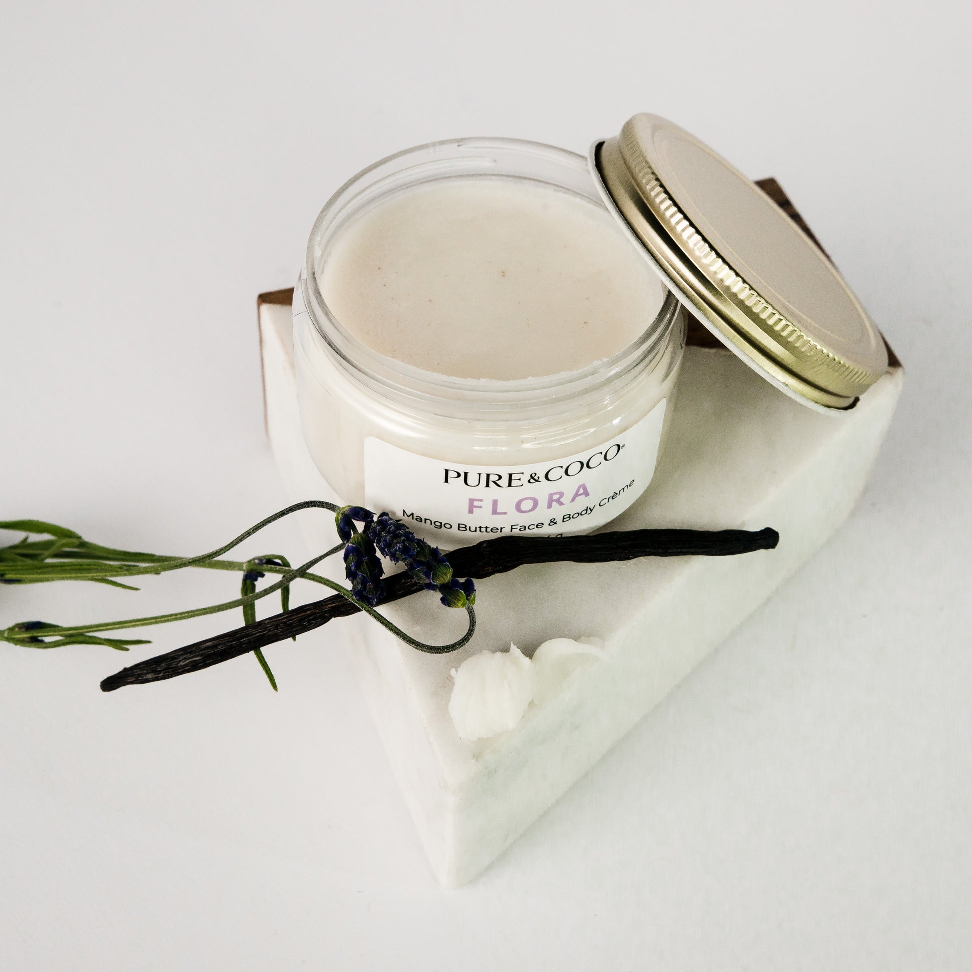 Open jar of Flora Mango Butter Crème showing creamy texture and rich hydration formula.