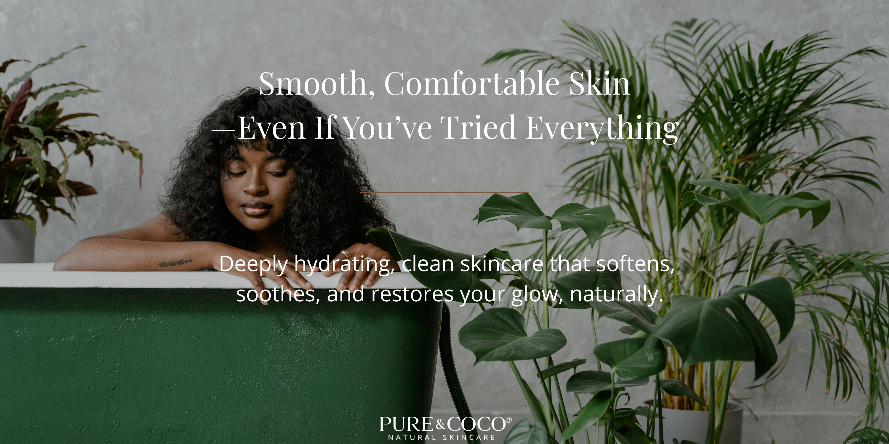 African-American woman relaxing in a green bathtub surrounded by plants, representing soft, hydrated skin from Pure & Coco’s natural coconut oil skincare for dry, sensitive skin
