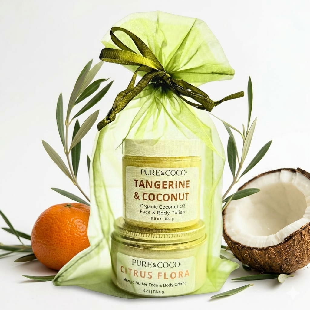 Pure & Coco Tangerine & Coconut Organic Body Polish and Citrus Flora Mango Butter Crème Gift Set. A translucent light green organza bag with a dark green ribbon bow contains two stacked jars: a 5.8 oz jar of organic face and body polish and a 4 oz jar of mango butter face and body crème. Surrounded by olive branches, a ripe tangerine, and a halved coconut on a clean white background.
